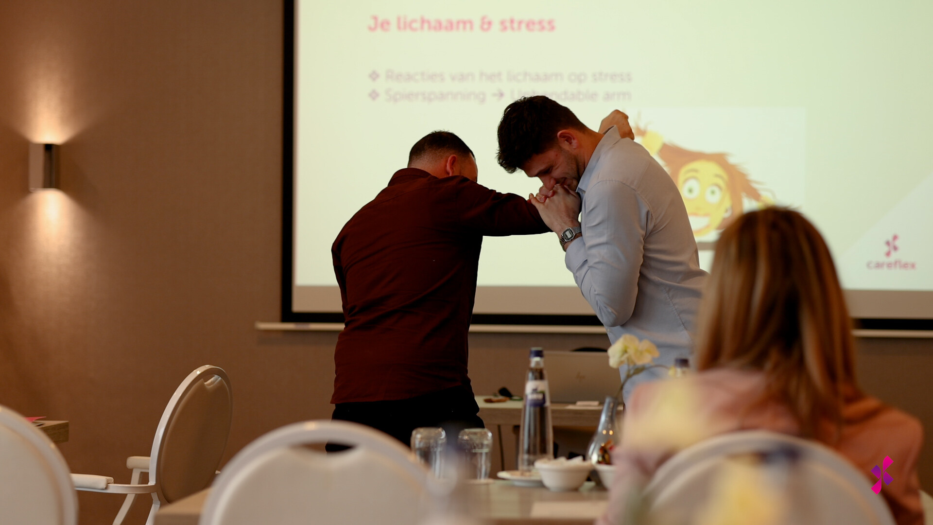 Een trainer doet een bevrijdingstechniek voor bij een deelnemer.