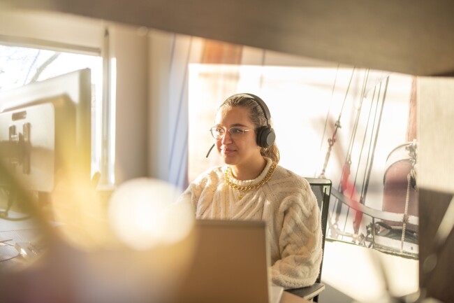 Een planner met een headset belt met een medewerker over het rooster.